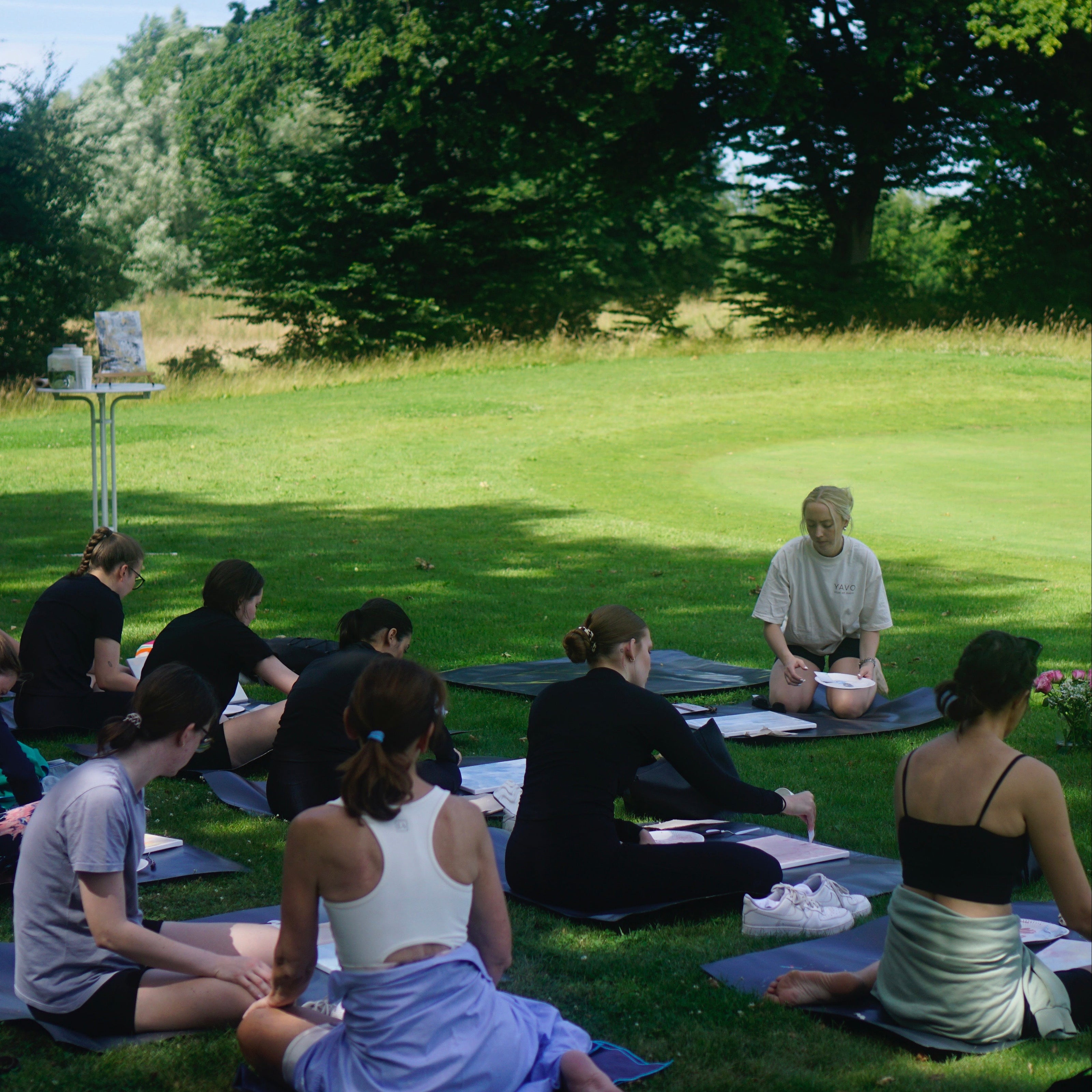 Malende Personen auf Wiese Outdoor Yoga und Paint 