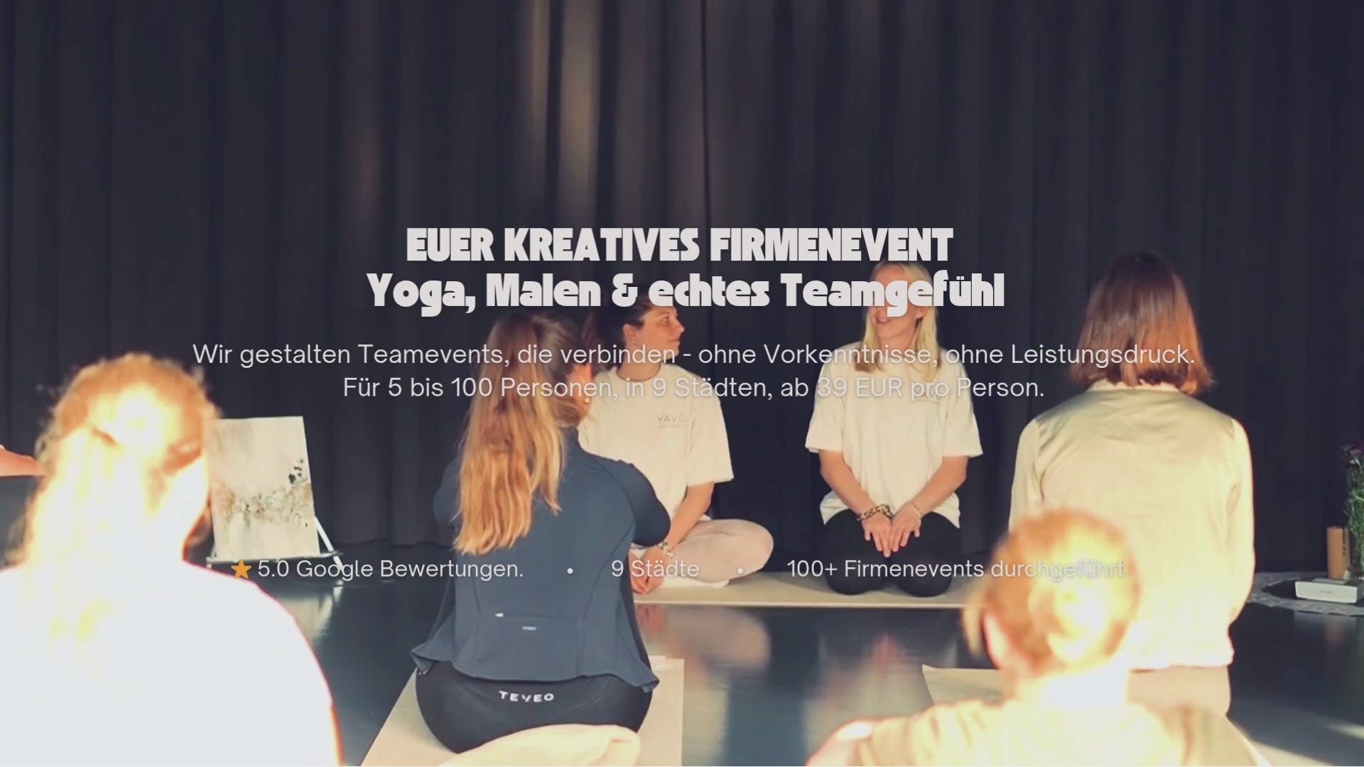 Video laden: Das Video zeigt ein Yoga und Kunstevent eines Teams in einer Firma. Es sind 15 Teilnehme anwesend die angeleitet durch eine Yogalehrerin Yoga machen und dann im weiteren Verlauf des Videos gemeinsam auf Leinwänden am Tisch malen.